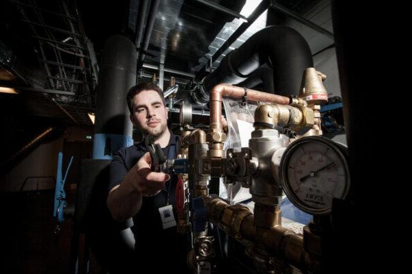 Male Mitie engineer working on pressurised pipes